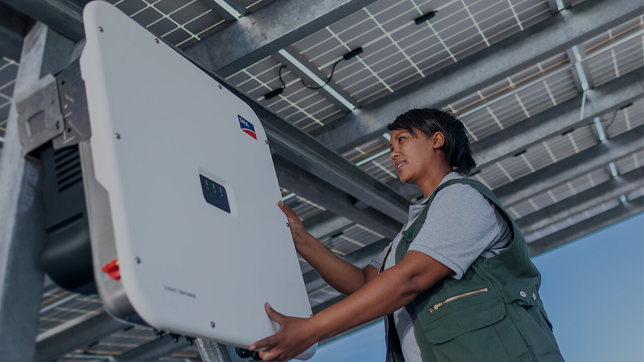 A female technician is working on an SMA inverter.